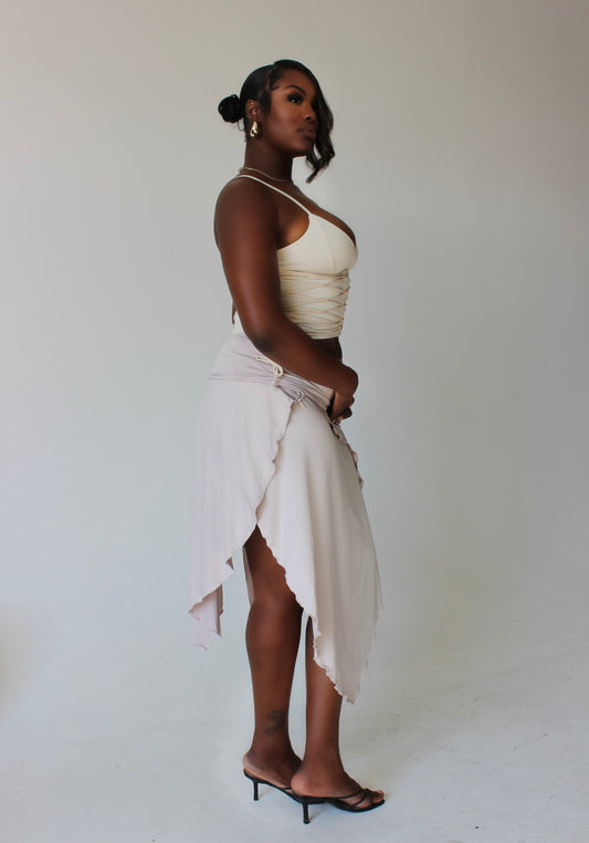 side profile of tall model in asymmetrical slit midi skirt with ruched detailing