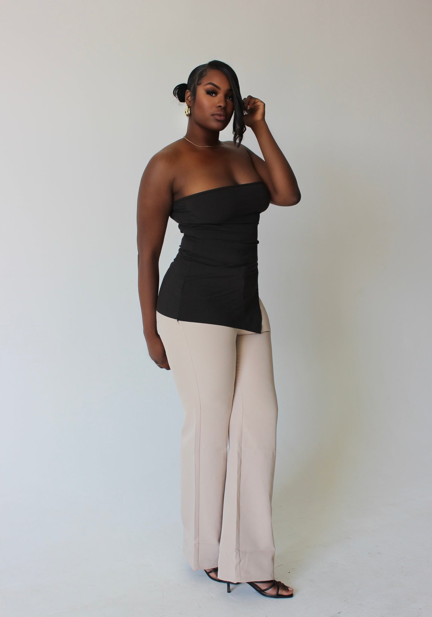 side angle of tall woman in irregular-cut brown tube top – luxury streetwear fit
